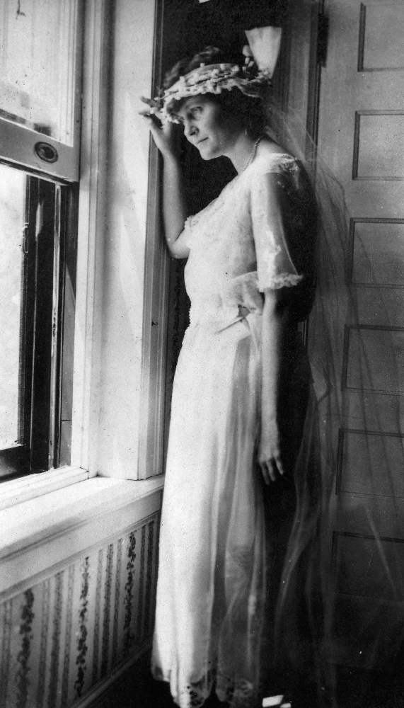 EH5726P Hadley Richardson in her wedding dress looking out the window on her wedding day in Horton Bay, MI, 3 September 1921. Please credit: "Ernest Hemingway Collection/John F. Kennedy Presidential Library and Museum, Boston."