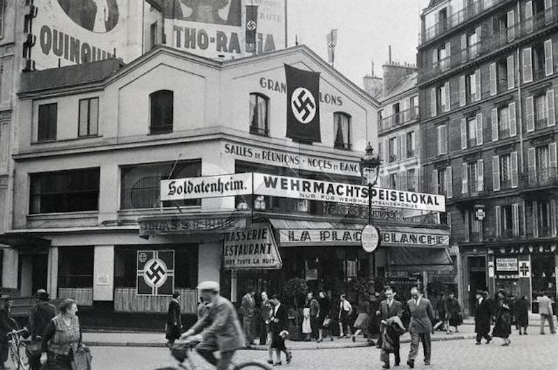 Nazi flags and German signs festoon La Place Blanche, the cafe across from the Moulin Rouge, in 1940. The cafe was reserved for exclusive use by occupying soldiers of the Wehrmacht. October 20, 1940 Paris, France
