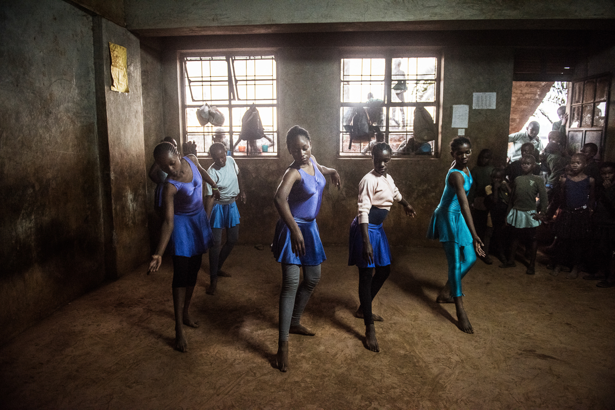 Some of the older girls is practicing a dance together, while the ballet class takes place there is always a whole group of curious students around the classroom/dance studio